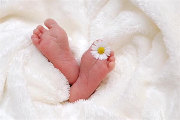 die Füße eines Babys mit einer Blume darauf